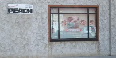 More of the Sauk Herald's 'Welcome Home' signs, and flags, in the window. Sauk Centre, Minnesota