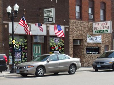 Sauk Centre's Mustang Bar: yellow ribbons galore on the window, flags overhead